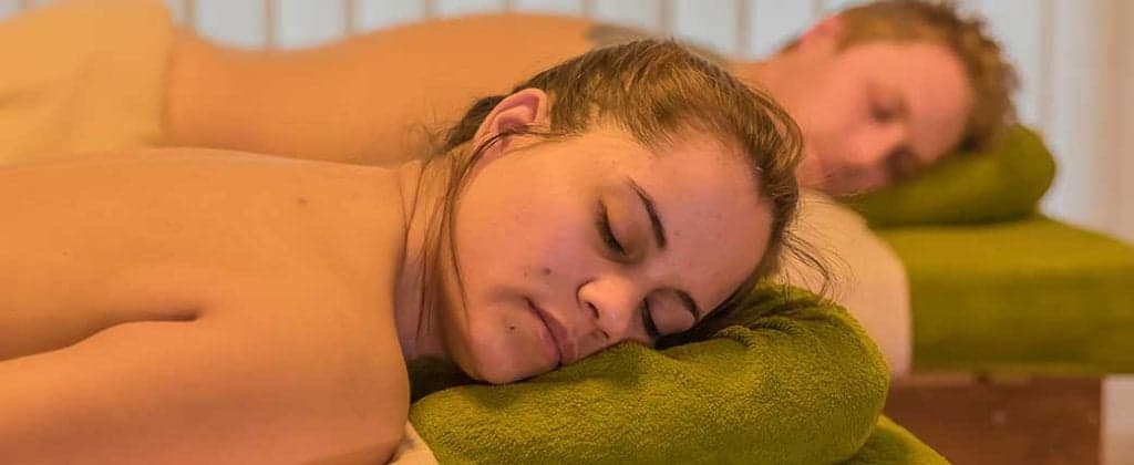 Zwei Personen liegen auf der Massageliege und warten auf die Massage