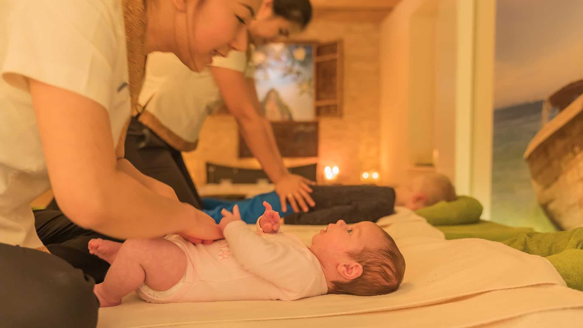 zwei Kinder werden parallel im Massageraum auf den Massageliegen massiert.